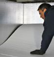 contractor installing TerraBlock™ floor insulation in a Big Lake crawl space