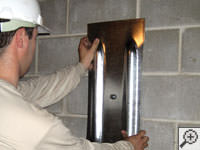 Mounting a foundation wall plate for an earth anchor installation in Haines.