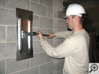 Attempting to straighten a bowed foundation wall by straightening a wall anchor system in a Big Lake home.