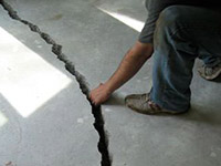 a severely damaged cracked concrete slab floor in Sutton