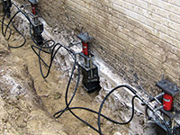 Using foundation push piers to lift a foundation during a repair in Cordova.