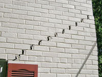 Stair-step cracks showing in a home foundation in Gakona