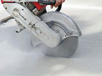 Cutting the driveway for expansion joints during street creep repair in Copper Center