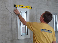 Positioning a wall plate cover on a foundation wall in Chugiak.