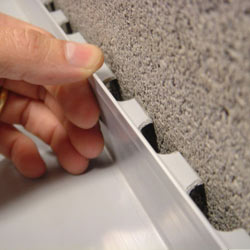 A contractor in Douglas installing a perimeter drain tile system during a sump pump installation.